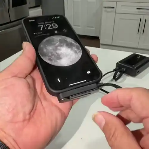 Telefon așezat în suport în timp ce se încarcă prin USB-C